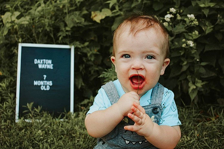 Daxton is registered to the contest to win money with this photo: baby, cheek, child, face, facial_expression, finger, grass, happy, head, leaf, person, photograph, photography, plant, portrait, portrait_photography, smile, toddler, tree