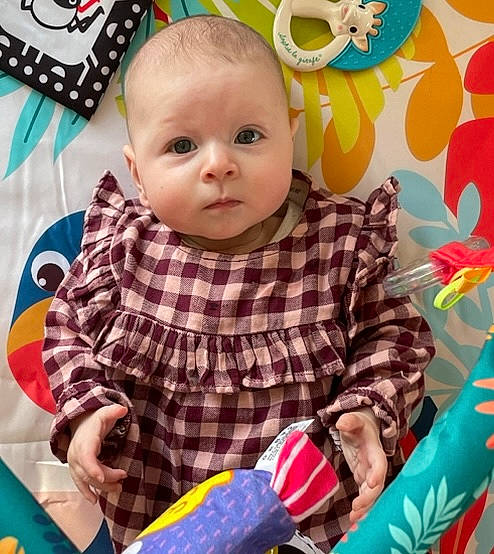 Lily a rejoint le concours — aidez-le/la à gagner de superbes lots ! baby, baby_playing_with_toys, baby_products, baby_toddler_clothing, baby_toys, cheek, child, facial_expression, fun, happy, pattern, person, petal, play, product, sitting, sleeve, t_shirt, textile, toddler