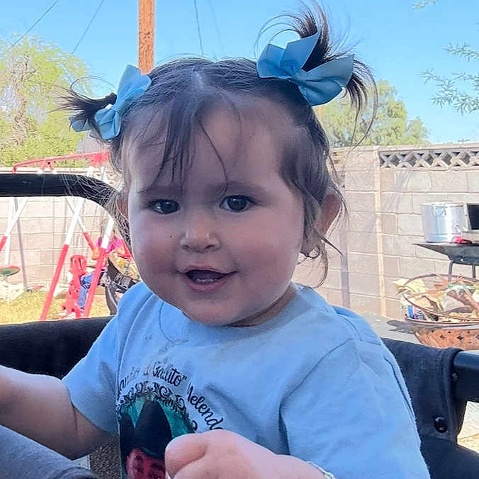 Leilanny joined the competition — help win amazing prizes! backyard, blue_bows, bracelet, brick_wall, casual, child, cute, daylight, hair, happy, outdoor, person, playful, portrait, shirt, smiling, sunny, swing_set, toddler, young_child
