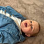 Capucine participe au concours pour gagner de l'argent avec cette photo : baby, infant, denim_jacket, white_shirt, happy, smiling, face, blue_eyes, soft_surface, fuzzy_blanket, clothing, child, cute, portrait, lying_down, skin, head, mouth_open, casual, indoors