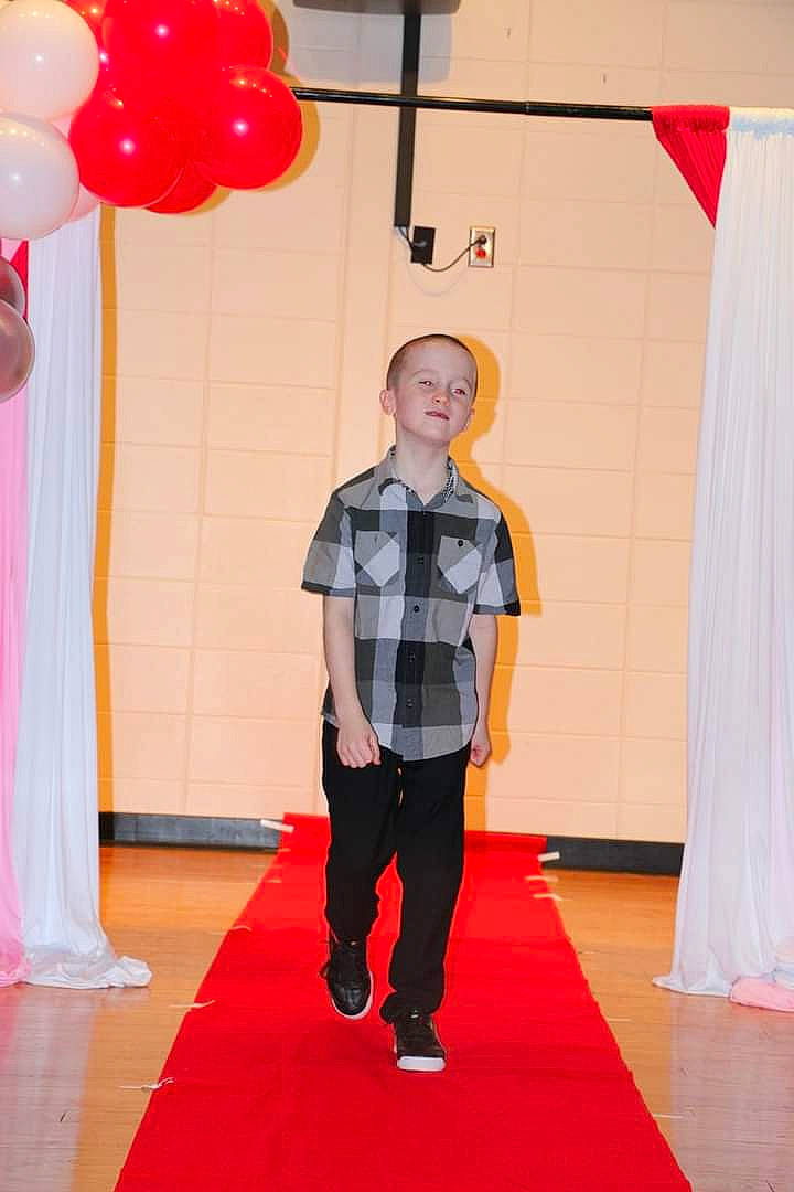Christopher is registered to the contest to win money with this photo: balloon, carpet, curtain, entertainment, event, fashion_design, flooring, formal_wear, fun, joint, leisure, magenta, orange, party_supply, pattern, performing_arts, person, public_event, red, red_carpet