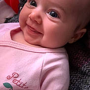 Joyce participe au concours pour gagner de l'argent avec cette photo : baby, blanket, blue_eyes, cheeks, chubby_cheeks, closeup, clothing, cozy, cute, expression, face, hair, happy, infant, lying_down, pink_onesie, plush_toy, portrait, skin, smiling