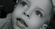 Hudson is registered to the contest to win money with this photo: child, portrait, close_up, black_and_white, smiling, teeth, eyes, curious, face, head, indoors, photography, grayscale, happy, looking_up, young, person, lightning, expression, background