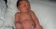 Zion is registered to the contest to win money with this photo: newborn, baby, sleeping, hospital, pillow, blanket, infant, skin, person, bed, foot, hand, wristband, rest, cute, indoors, soft, healthcare, peaceful, lying_down