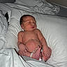 newborn, baby, sleeping, hospital, pillow, blanket, infant, skin, person, bed, foot, hand, wristband, rest, cute, indoors, soft, healthcare, peaceful, lying_down