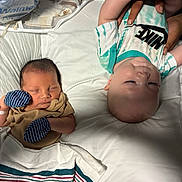 Zion joined the competition — help win amazing prizes! baby, newborn, infant, sleeping, mitten, blanket, clothing, person, bed, white, cute, toddler, nike, striped, hand, face, skin, lying_down, sibling, peaceful