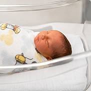 Zion is registered to the contest to win money with this photo: newborn, baby, infant, sleeping, blanket, hospital, bassinet, swaddled, peaceful, cute, face, head, resting, child, soft, cartoon, cloth, hospital_bed, newborn_care, toddler