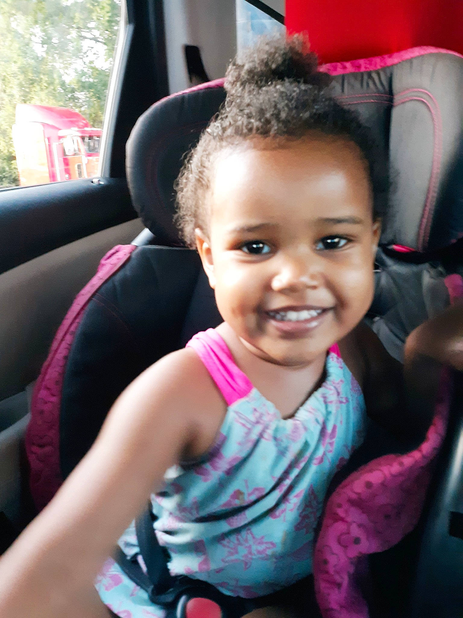 Destini joined the competition — help win amazing prizes! auto_part, baby_in_car_seat, black_hair, car_seat, cheek, child, face, head, joy, lip, person, pink, sitting, skin, smile, steering_wheel, toddler