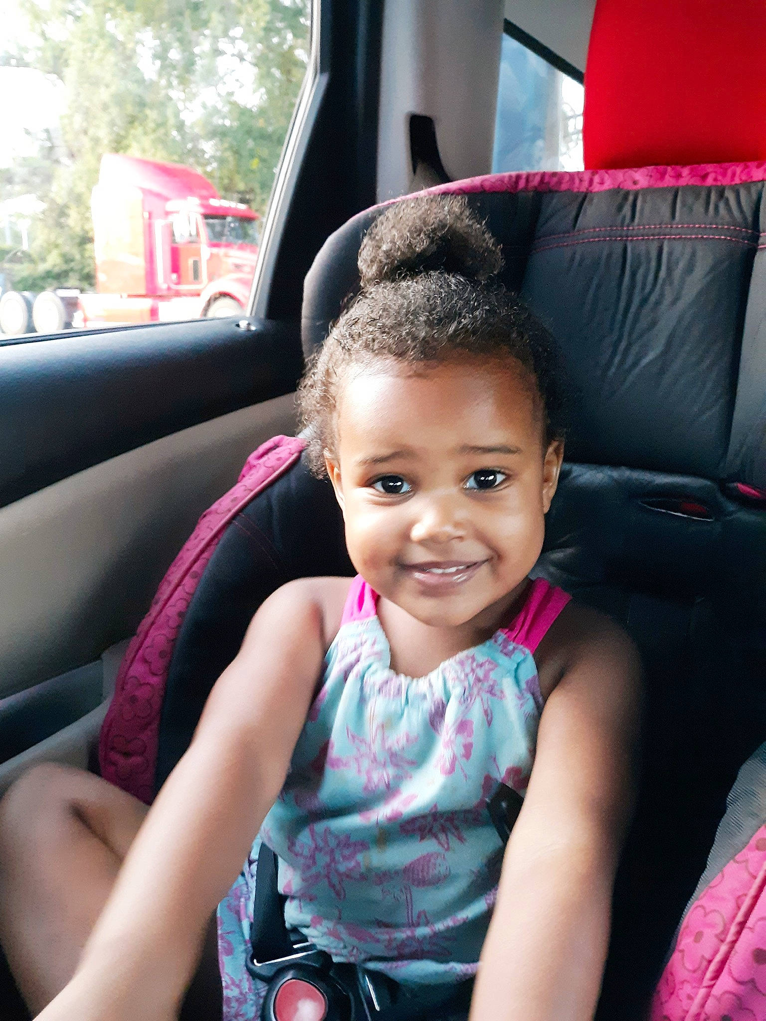 Destini is registered to the contest to win money with this photo: auto_part, black_hair, car, car_seat, car_seat_cover, child, driving, family_car, joy, person, pink, seat_belt, sitting, skin, smile, steering_part, steering_wheel, toddler, vacation, vehicle