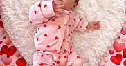 Cambree is registered to the contest to win money with this photo: baby, infant, heart_shape, red_bow, pink_onesie, hearts_pattern, fluffy_cushion, cute, adorable, lying_down, background_hearts, love_theme, soft_texture, newborn, portrait, child, smiling, holiday_theme, valentines, cozy