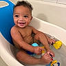 Zyaire is registered to the contest to win money with this photo: baby, bathtub, water, toy, rubber_duck, bathroom, smile, child, happy, sitting, skin, wet, curly_hair, blue, yellow, white, tile, bath, cute, infant