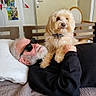 Pépette participe au concours pour gagner de l'argent avec cette photo : elderly_man, dog, indoor, bed, pillow, glasses, white_hair, beard, furniture, wooden_headboard, black_clothing, light_brown_dog, pet, resting, comfort, curious_dog, human_animal_interaction, casual, relaxation, home
