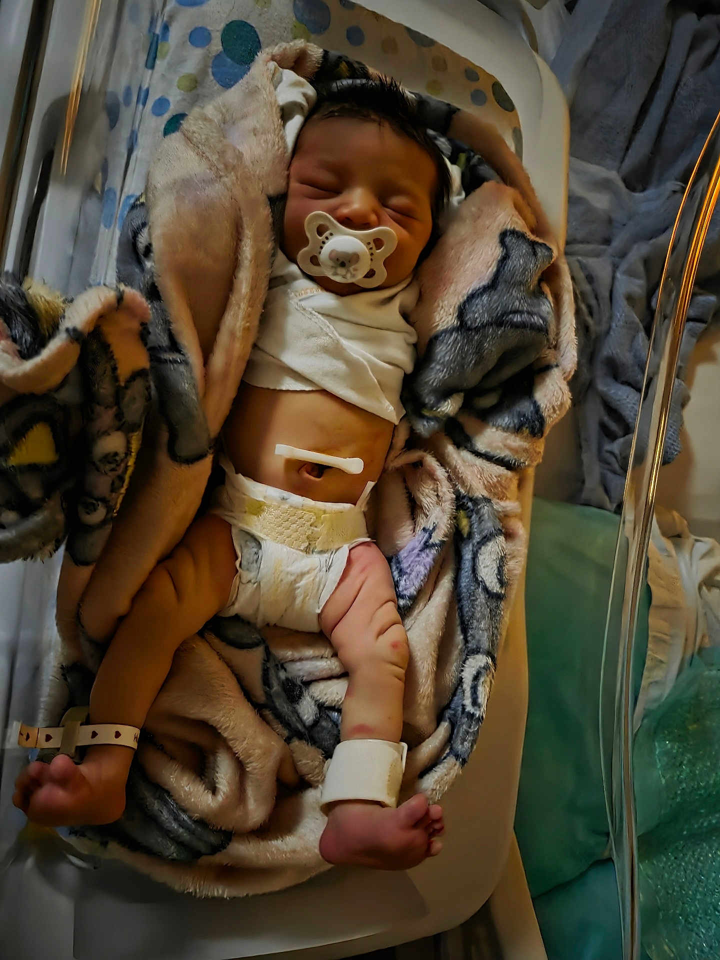 Star is registered to the contest to win money with this photo: newborn, baby, infant, sleeping, pacifier, blanket, diaper, hospital, crib, soft_toys, wrapped, legs, feet, wrists, calm, indoors, bed, cute, peaceful, child