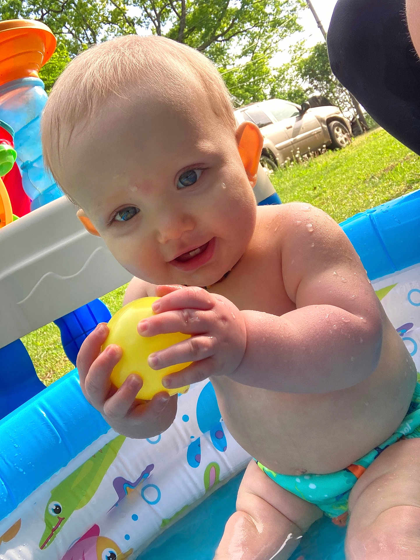 Rorik is registered to the contest to win money with this photo: baby, car, clothing, diaper, face, grass, head, nature, outdoors, person, photography, plant, pool, portrait, summer, swimwear, transportation, vehicle, water, yard