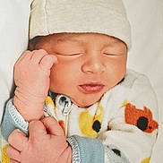 Taydrian is registered to the contest to win money with this photo: newborn, baby, infant, sleeping, hat, onesie, cute, hands, closed_eyes, soft, cozy, patterned_clothing, peaceful, portrait, child, indoors, warm, rest, skin, closeup
