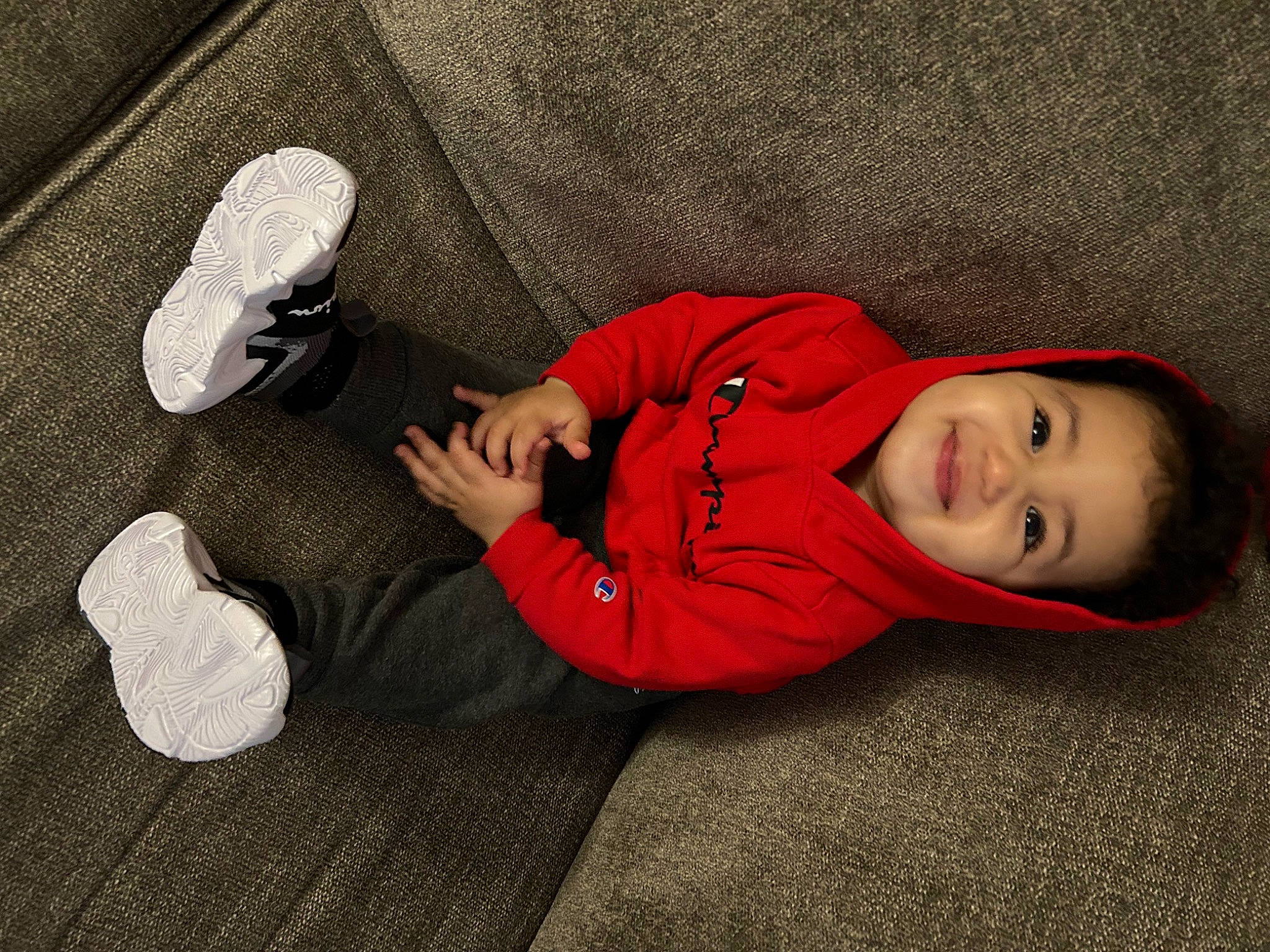 Jahkarri is registered to the contest to win money with this photo: baby_toddler_clothing, carmine, child, comfort, flash_photography, floor, flooring, foot, grass, happy, head, human_leg, joy, knee, linens, person, sitting, sleeve, smile, sock