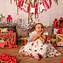 child, clothing, cream, dessert, dress, face, female, festival, flower, flowerarrangement, flowerbouquet, food, girl, head, icing, people, person, plant, sitting, sweets