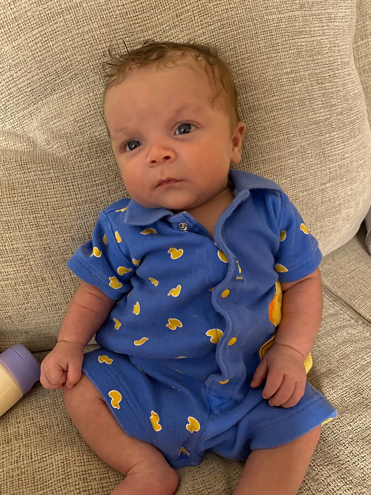 Zamier is registered to the contest to win money with this photo: baby, bodypart, chair, clothing, couch, cushion, face, finger, furniture, hand, head, homedecor, pants, pattern, person, photography, portrait, shirt, sitting, sleeve