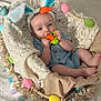Jericho is registered to the contest to win money with this photo: baby, bunny_ears, carrot_teether, blue_outfit, basket, lace, easter_eggs, colorful, cute, infant, chewing, headband, soft_toy, decorations, fabric, footwearless, indoors, smiling, child, playful