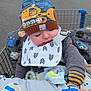 Jericho joined the competition — help win amazing prizes! baby, child, shopping_cart, hat, knit_hat, mittens, bib, blanket, parking_lot, person, hand, outdoor, winter_clothing, cute, sleeping, cart, toy, fabric, pattern, warm