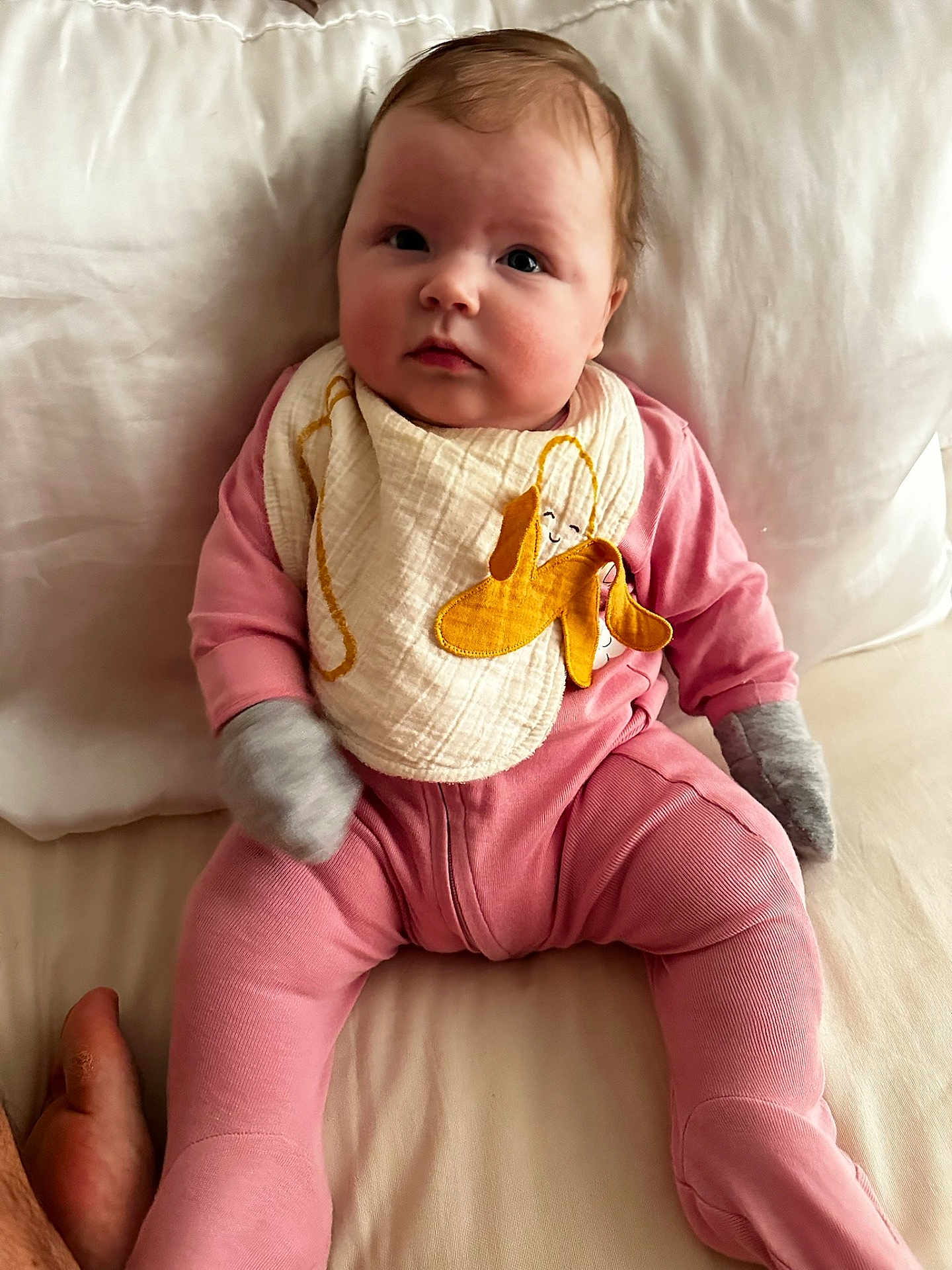 Olivia joined the competition — help win amazing prizes! baby, infant, child, pink_pajamas, mittens, bib, yellow_bunny, soft_lighting, white_bed, couch, cute, chubby_cheeks, portrait, indoors, sitting, young_child, person, cozy, comfortable, expression