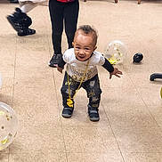 Kyrie joined the competition — help win amazing prizes! toddler, child, smile, playful, balloons, party, indoor, floor, clothing, gold_chain, sneakers, legs, people, celebration, festive, person, young_child, red_shirt, purple_jacket, black_pants