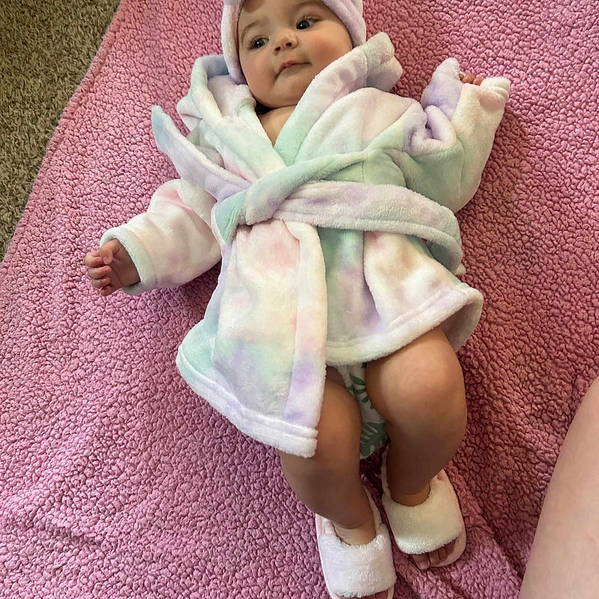 Mia is registered to the contest to win money with this photo: baby, bathrobe, blanket, carpet, child, clothing, comfortable, cute, floor, headwrap, indoor, infant, pastel, person, pink, portrait, relaxing, slippers, soft, towel