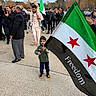adult, autumn, boy, child, children, community, crowd, family, flag, freedom_flag, gathering, outdoor, parade, patriotic, pavement, people, shoulders, smiling, standing, trees