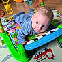 baby, infant, playmat, toy, piano, colorful, floor, child, blue_clothing, playtime, cute, indoors, smiling, face, hands, head, toys, bright, young_child, crawling