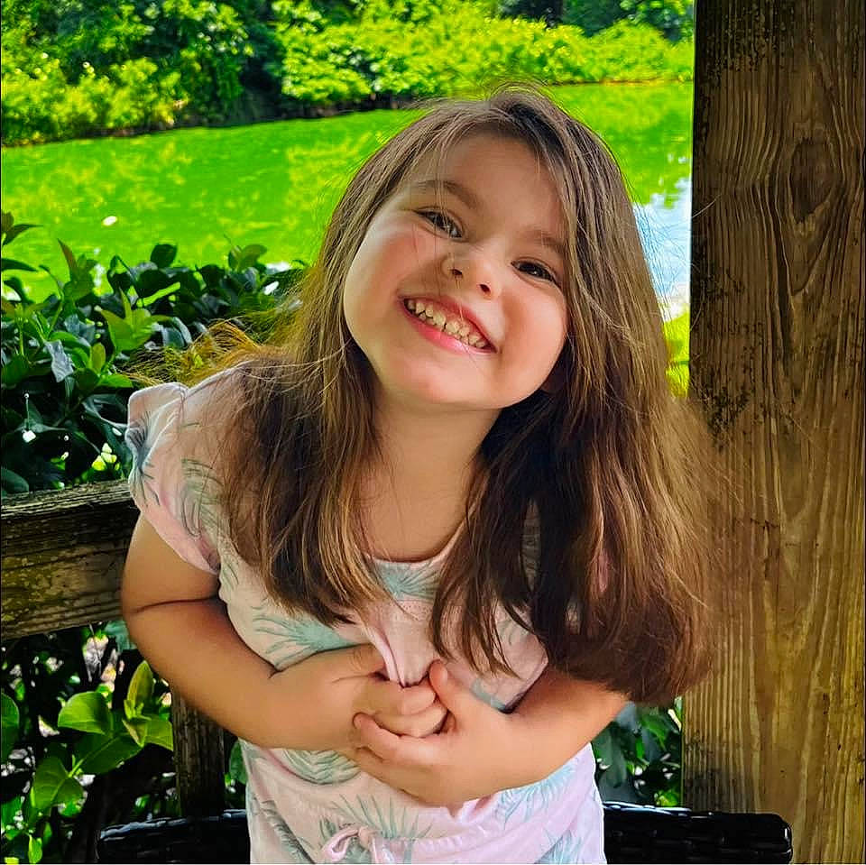 Norah is registered to the contest to win money with this photo: beauty, botany, child, eye, facial_expression, gesture, grass, green, hairstyle, hand, happy, iris, joy, leaf, lip, long_hair, people_in_nature, person, plant, skin