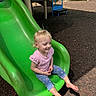 toddler, child, slide, playground, green_slide, barefoot, smiling, outdoor, sunlight, mulch, blue_pants, pink_shirt, short_sleeves, blonde_hair, happy, leisure, park, daytime, play, casual_clothing