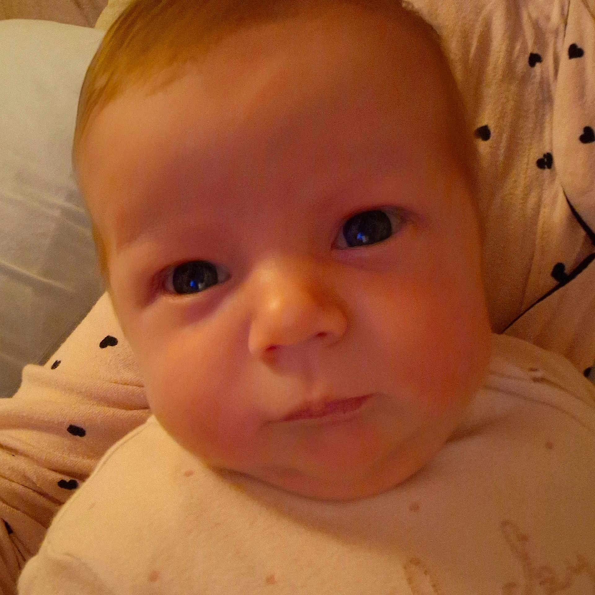 Lydia is registered to the contest to win money with this photo: baby, cheeks, child, close_up, clothing, cute, expression, eyes, face, head, indoors, infant, newborn, pattern, person, portrait, resting, skin, soft, warm