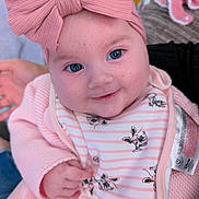 Sienna joined the competition — help win amazing prizes! baby, pink_bow, blue_eyes, smile, knitwear, bib, cartoon_characters, closeup, infant, cute, child, portrait, hand, clothing, indoor, soft_texture, person, headwear, happy, skin