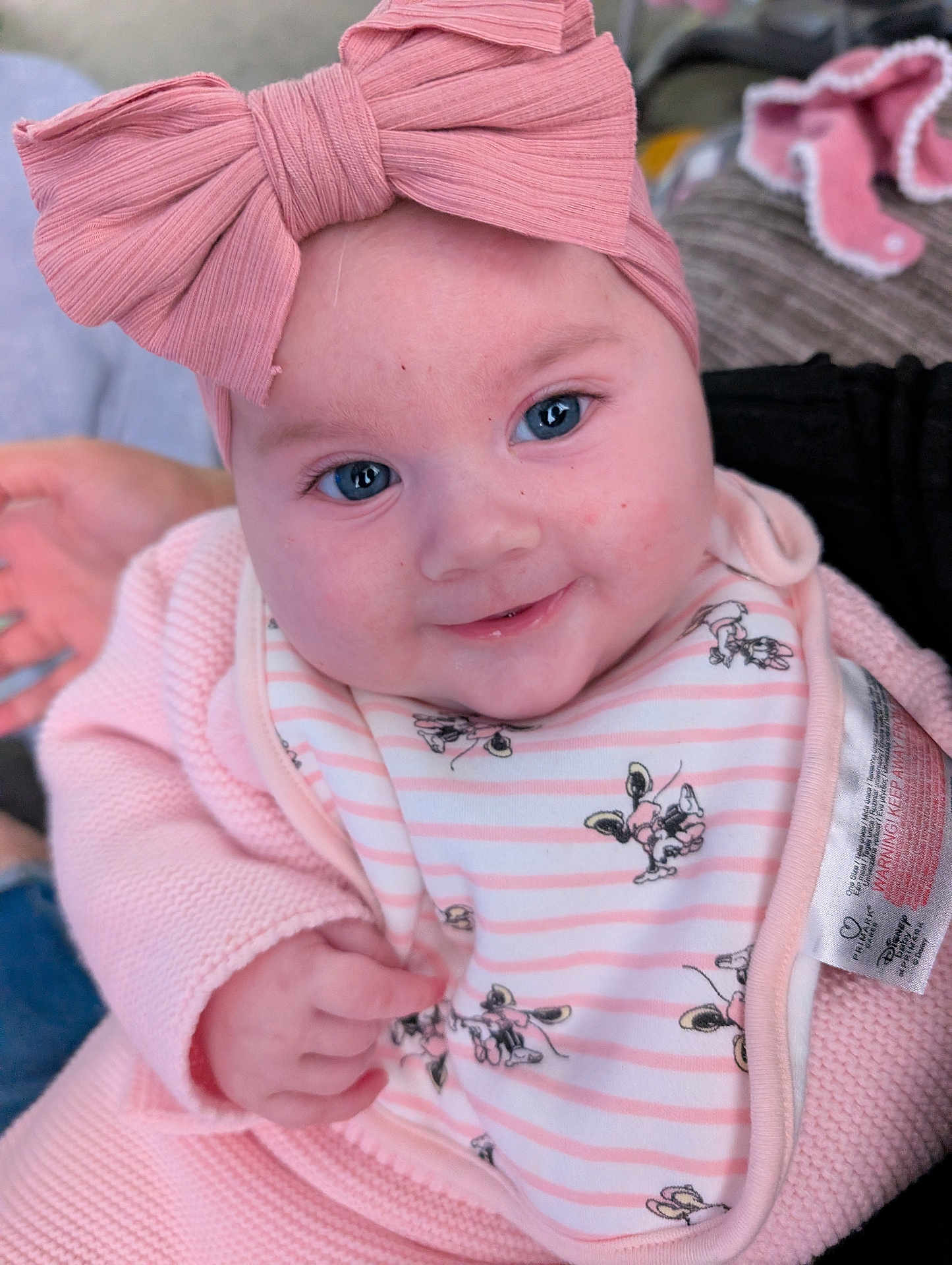 Sienna joined the competition — help win amazing prizes! baby, pink_bow, blue_eyes, smile, knitwear, bib, cartoon_characters, closeup, infant, cute, child, portrait, hand, clothing, indoor, soft_texture, person, headwear, happy, skin