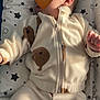 baby, infant, pajamas, bear_pattern, sleeping, pillow, stars_pattern, blanket, child, cute, soft, clothing, toddler, indoors, peaceful, resting, warm, zipped_jacket, fabric, bedtime