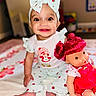 baby, child, doll, headband, bow, smile, happy, indoor, clothing, toy, sitting, blanket, cute, pink, red_hair, face, person, play, infant, portrait