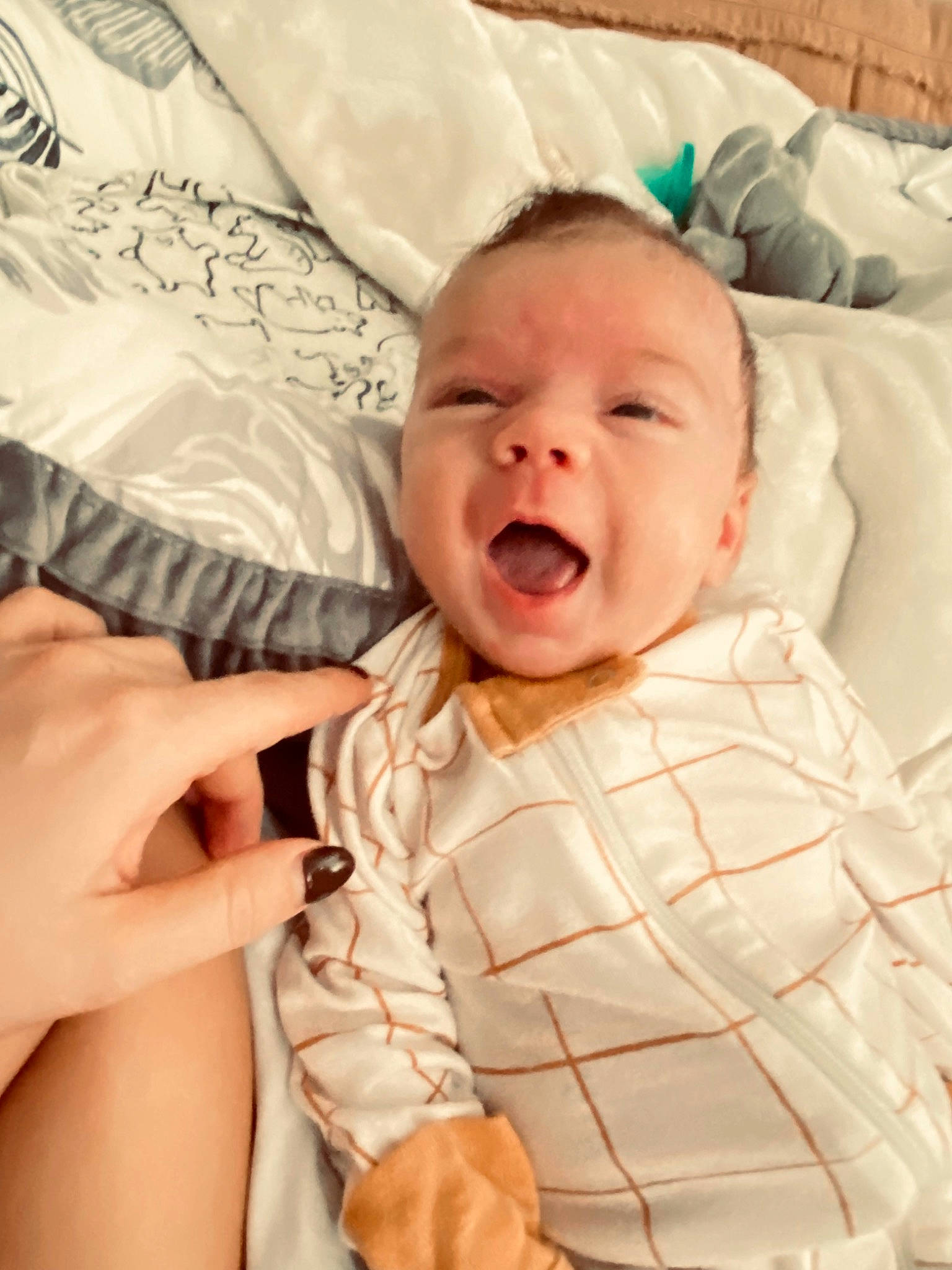 Benji is registered to the contest to win money with this photo: baby, baby_toddler_clothing, bed, cheek, comfort, event, eye, face, finger, gesture, happy, head, iris, linens, lip, mouth, nose, person, skin, smile