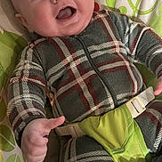 Rhett is registered to the contest to win money with this photo: baby, infant, smiling, plaid_clothing, onesie, baby_seat, child, happy, face, blue_eyes, playful, monkey_pattern, green, leaf_pattern, fabric, cute, indoor, person, seatbelt, young_child