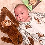 animal_print, baby, book, child, childrens_book, cute, face, infant, lying_down, monkey, plush_toy, portrait, reading, smiling, soft_texture, striped_clothing, stuffed_animal, toddler, toy, white_background
