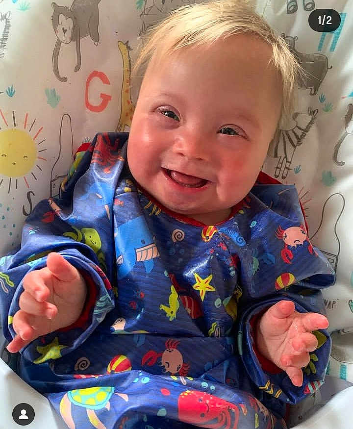 Killian participe au concours pour gagner de l'argent avec cette photo : baby, child, smiling, happy, blue_clothing, high_chair, ocean_theme, cartoon_animals, indoor, portrait, cute, infant, toddler, colorful, playful, face, hands, cheerful, blond_hair, bright