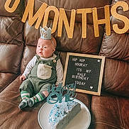 Killian participe au concours pour gagner de l'argent avec cette photo : baby, banner, birthday, cake, celebration, child, clothing, couch, crown, decoration, food, half_birthday, happy, indoor, infant, party, portrait, signboard, sitting, sock
