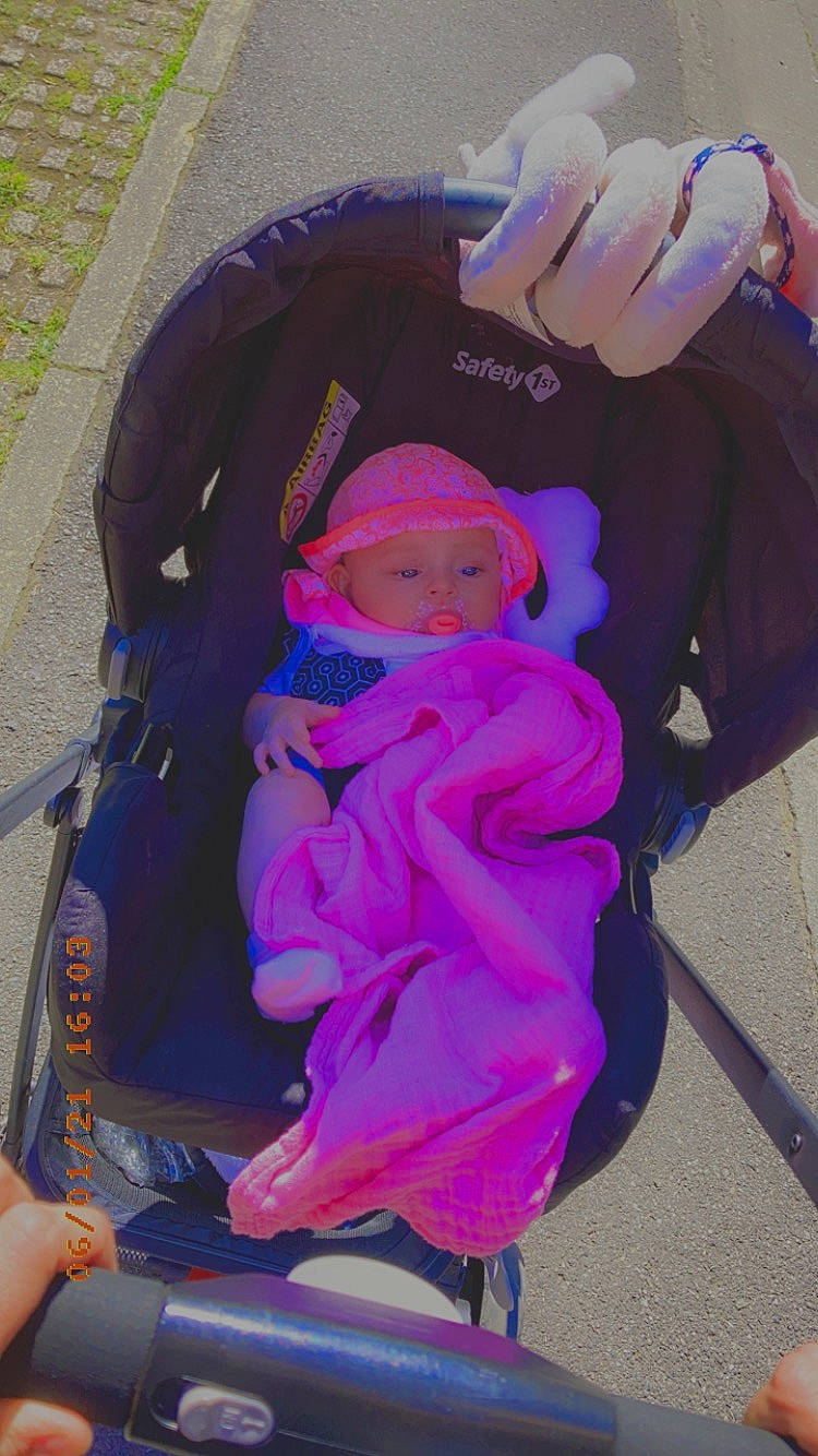 Aline a rejoint le concours — aidez-le/la à gagner de superbes lots ! baby, baby_carriage, baby_products, baby_toddler_clothing, bag, child, electric_blue, fashion_accessory, gesture, grass, headwear, magenta, person, pink, purple, sitting, thumb, toddler, violet