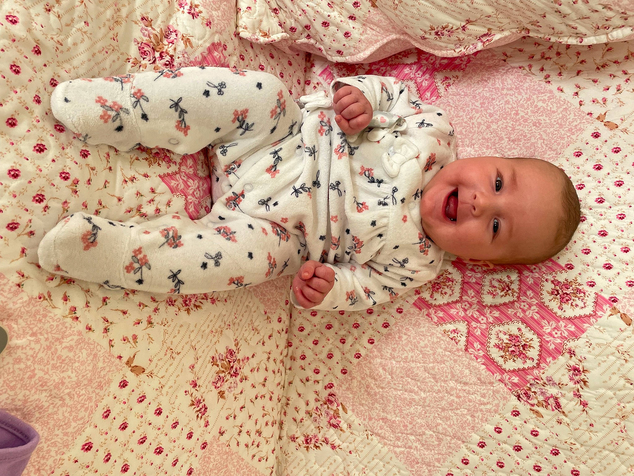 Léna a rejoint le concours — aidez-le/la à gagner de superbes lots ! baby, baby_toddler_clothing, carmine, child, comfort, flooring, foot, head, joy, kneeling, linens, nightwear, pattern, person, pink, sleeve, smile, textile, toddler