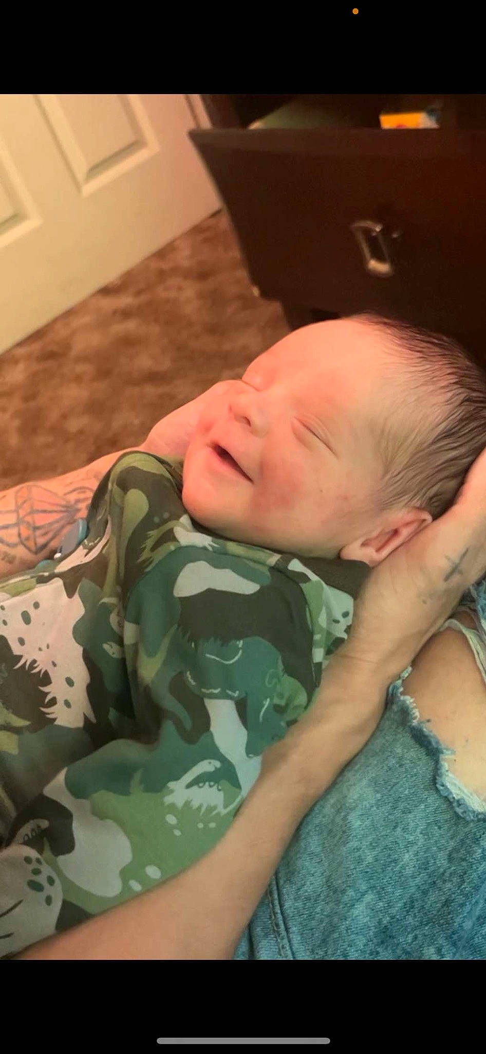 Braxton is registered to the contest to win money with this photo: baby, baby_toddler_clothing, camouflage, cheek, child, comfort, eye, face, flooring, human_body, military_camouflage, military_person, military_uniform, mouth, pattern, person, skin, sleeve, smile, thumb