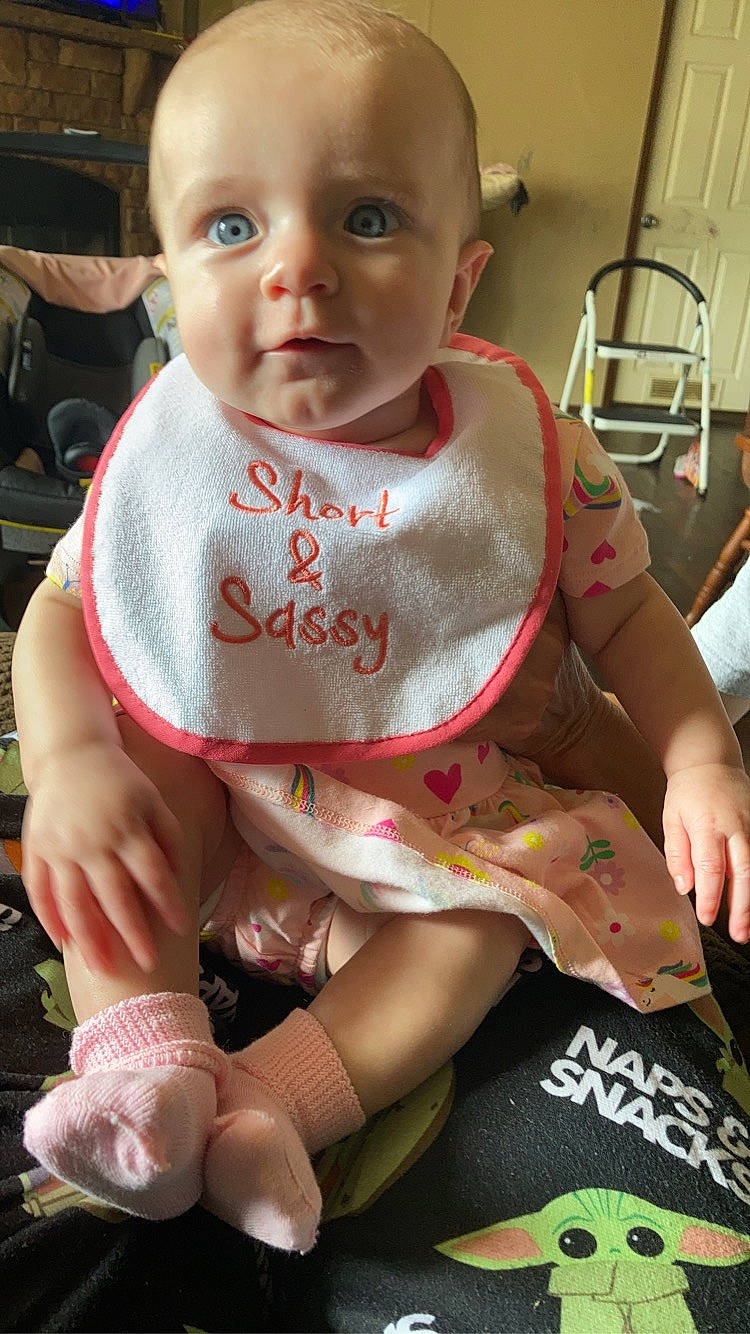 Khloe is registered to the contest to win money with this photo: baby, baby_carriage, baby_toddler_clothing, bib, chair, cheek, chest, child, comfort, eye, finger, hand, head, joint, knee, person, seat_belt, skin, sleeve, thigh