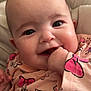 Ambre participe au concours pour gagner de l'argent avec cette photo : baby, smiling, close_up, face, hand, pink_clothing, butterfly_pattern, bow_pattern, chubby_cheeks, bright_eyes, infant, cute, happy, indoors, soft_light, child, person, apparel, sitting, playful