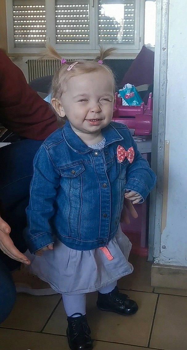 Léonie a rejoint le concours — aidez-le/la à gagner de superbes lots ! baby_toddler_clothing, cheek, denim, door, electric_blue, face, gas, head, iris, joint, pattern, person, pink, room, sitting, skin, sleeve, smile, sock, toddler