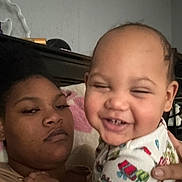 Kristian is registered to the contest to win money with this photo: adult, baby, candid, child, closeup, clothing, cozy, expression, face, family, furniture, hand, holding, indoor, pajamas, person, portrait, skin, smiling, wall