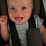 baby, child, smile, happy, car_seat, seatbelt, infant, face, eyes, hand, clothing, person, safety, straps, closeup, cute, joy, indoors, young, portrait