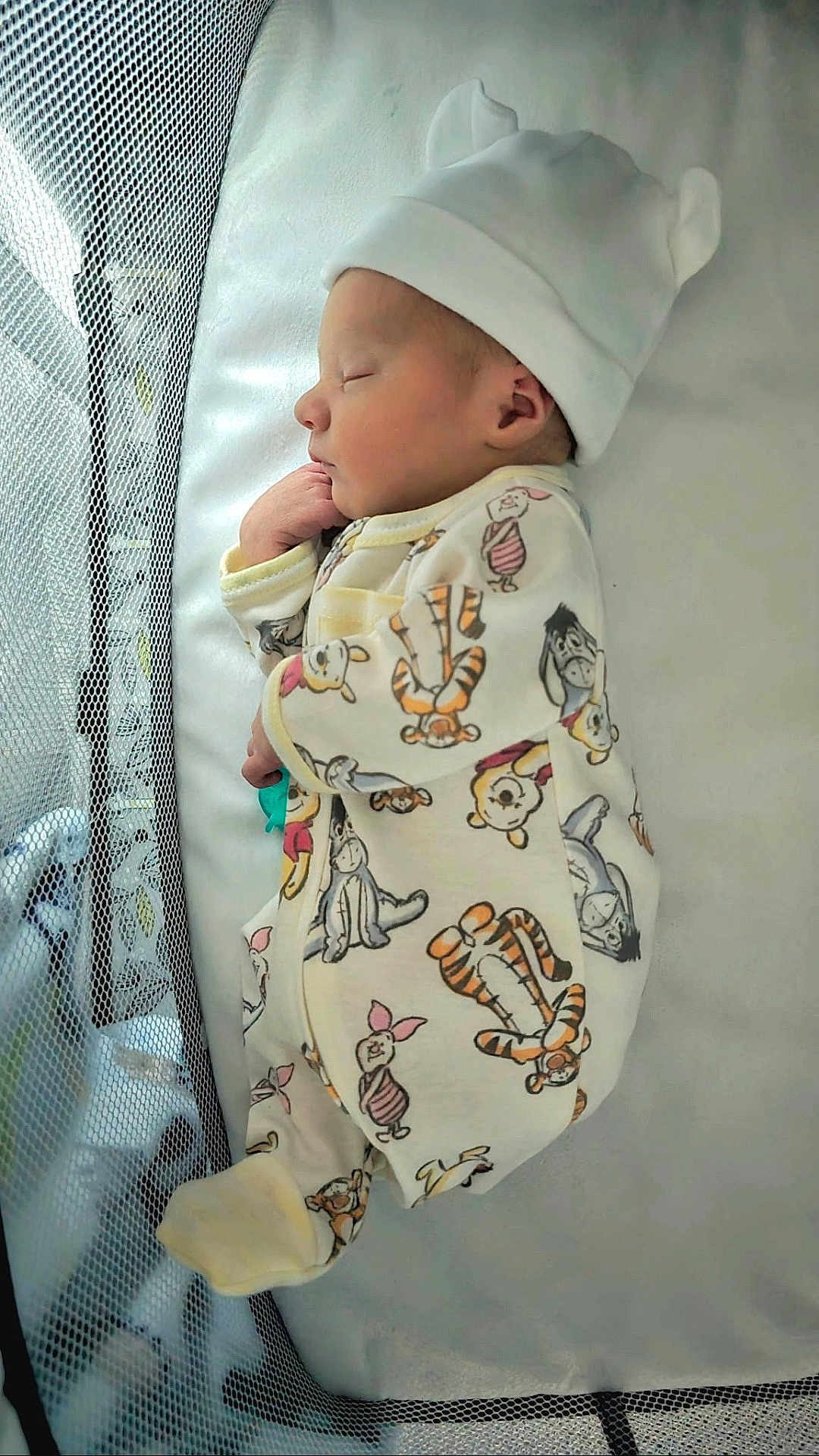 Liam is registered to the contest to win money with this photo: newborn, baby, sleeping, crib, mesh, hat, onesie, cartoon_characters, cute, cozy, infant, soft, peaceful, resting, child, bed, pajamas, closeup, indoors, portrait